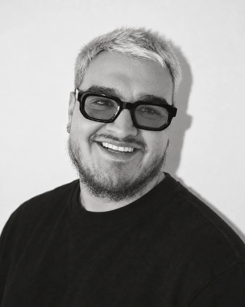 Kenny Palacios smiling, in black and white